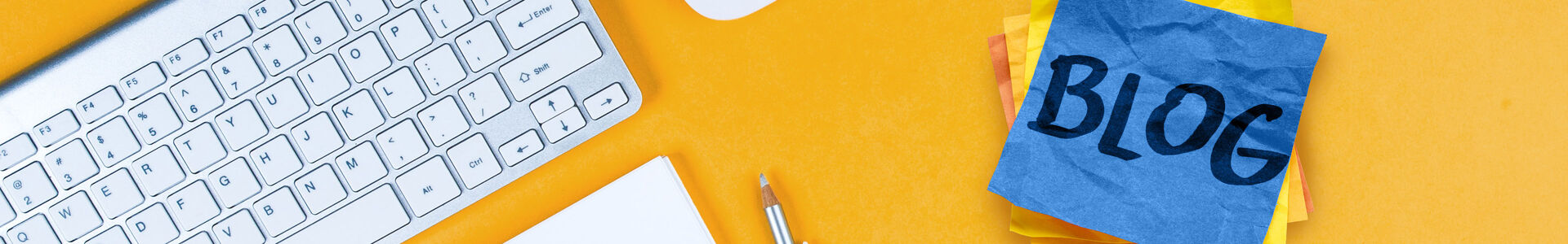 Schreibtisch mit Tastatur und Notizzetteln mit der Aufschrift Blog