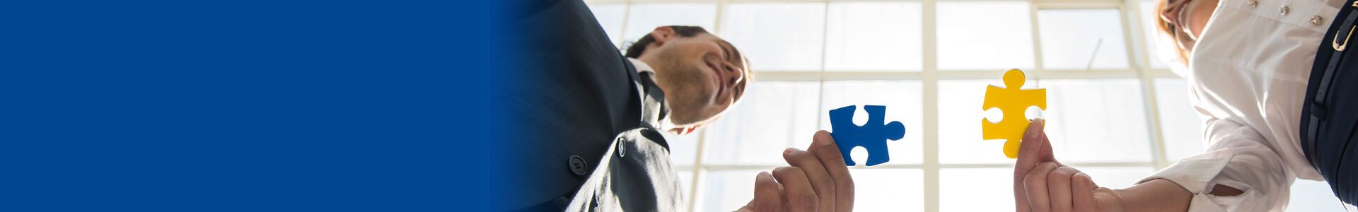 Ein Mann und eine Frau kommen mit passenden Puzzlestücken aufeinander zu