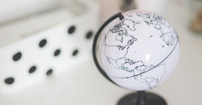 kleiner Globus in weiß mit schwarz eingezeichneten Kontinenten