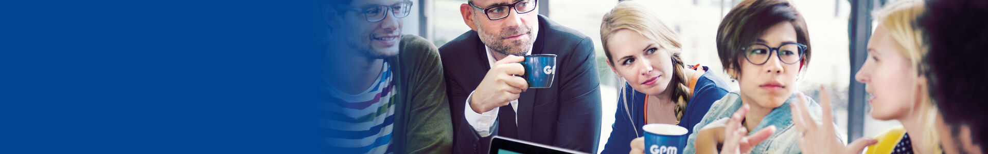 Menschen diskutieren in Arbeitsumgebung und trinken Kaffee aus GPM Tassen